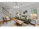 Sunlit living room features hardwood floors and views to front door and stairway at 15 Gray Fox Ct, Durham, NC 27713