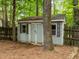 Close up view of shed in backyard surrounded by privacy fence and trees at 15 Gray Fox Ct, Durham, NC 27713