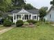 Well-maintained home featuring a lush front yard, flower beds, and a charming covered entry at 1615 Bickett Blvd, Raleigh, NC 27608