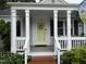 Inviting front porch with classic white columns, a decorative door, and a cozy atmosphere at 1615 Bickett Blvd, Raleigh, NC 27608