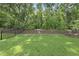 Lush green backyard with well-maintained lawn, a fence and mature trees, offering privacy and space at 167 Monteith Dr, Chapel Hill, NC 27516