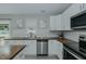 Bright kitchen with butcher block counters, white cabinets, stainless steel appliances, and a kitchen island at 169 Forest Dr, Graham, NC 27253