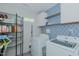 Laundry room with blue patterned wall, shelving, white washer and dryer and tile floor at 169 Forest Dr, Graham, NC 27253