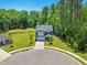 Aerial view of gray two-story house on cul-de-sac, featuring a manicured lawn and tree-lined backdrop at 187 Harpers Landing Rd, Garner, NC 27529