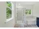 Bright bathroom featuring a glass shower, soaking tub, and window with scenic views at 187 Harpers Landing Rd, Garner, NC 27529