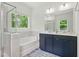 Bathroom with a glass shower, soaking tub, and double vanity with dark wood cabinets at 187 Harpers Landing Rd, Garner, NC 27529