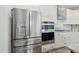 A modern kitchen with stainless steel appliances, white cabinets, and stylish backsplash at 187 Harpers Landing Rd, Garner, NC 27529