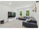 Spacious living room featuring a dark sectional sofa, media center, and natural light at 187 Harpers Landing Rd, Garner, NC 27529