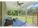 Relaxing screened porch with comfortable seating, a ceiling fan, and views of the lush backyard at 187 Harpers Landing Rd, Garner, NC 27529