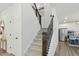 Carpeted staircase featuring dark wood banisters and open design; kitchen view in background at 187 Harpers Landing Rd, Garner, NC 27529
