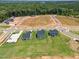Aerial view of new construction neighborhood featuring tree lined streets and green lawns at 210 Bluebell St, Sanford, NC 27330