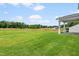 Expansive backyard featuring green lawn and tree line at 210 Bluebell St, Sanford, NC 27330