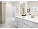 Bright bathroom featuring a shower over tub, dual vanity sink, and white cabinetry at 210 Bluebell St, Sanford, NC 27330