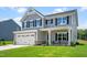 Attractive two-story home featuring gray siding, a large front lawn, and a welcoming entrance at 210 Bluebell St, Sanford, NC 27330