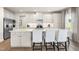 Bright kitchen featuring a large island with seating, white cabinetry, stainless steel appliances and modern lighting at 210 Bluebell St, Sanford, NC 27330