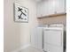 Functional laundry room with modern washer and dryer, white cabinetry, and tile flooring at 210 Bluebell St, Sanford, NC 27330