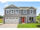Charming two-story home featuring a grey exterior, a two-car garage, and a vibrant red front door at 214 Bluebell St, Sanford, NC 27330