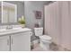 Clean bathroom with a vanity, toilet, shower with a curtain, and a gray wall creating a relaxing and functional space at 2310 Turning Pointe Way, Hillsborough, NC 27278