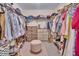 Walk-in closet with ample storage, including shelving, drawers, and a central ottoman for added convenience at 2310 Turning Pointe Way, Hillsborough, NC 27278