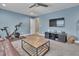 A spacious living room with exercise equipment, a sofa, a coffee table, and a large TV at 2310 Turning Pointe Way, Hillsborough, NC 27278
