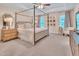 Large main bedroom featuring a four-poster bed, sitting area, and tray ceiling at 2310 Turning Pointe Way, Hillsborough, NC 27278