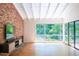 Cozy living room with hardwood floors, large windows, and exposed brick at 26 Mt. Bolus Rd, Chapel Hill, NC 27514
