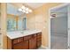 Vanity in bathroom with wood cabinets, granite countertop, large mirror, and natural lighting at 2614 Laurelcherry St, Raleigh, NC 27612