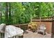 Outdoor deck featuring wooden flooring, a grill, seating, and lush greenery, perfect for relaxation and entertaining at 2614 Laurelcherry St, Raleigh, NC 27612