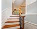 Elegant staircase featuring wooden steps, wrought iron railings, and white wainscoting, creating a timeless design at 2614 Laurelcherry St, Raleigh, NC 27612