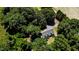 Aerial view of a home nestled among trees, featuring a large yard and driveway at 2642 Holly Springs Church Rd, Broadway, NC 27505