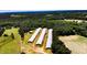 Aerial view of a property featuring several agricultural buildings surrounded by lush greenery at 2642 Holly Springs Church Rd, Broadway, NC 27505