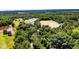 Aerial view showcases a home and several agricultural buildings surrounded by fields and lush, green forest at 2642 Holly Springs Church Rd, Broadway, NC 27505