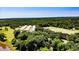 Aerial shot featuring several structures, a pond, large trees, and a vast field at 2642 Holly Springs Church Rd, Broadway, NC 27505