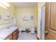 Well-lit bathroom featuring a vanity, toilet, decorative wall hangings and tiled floor at 2642 Holly Springs Church Rd, Broadway, NC 27505