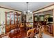 Formal dining room with hardwood floors, china cabinet, chandelier and open view of the living room at 2642 Holly Springs Church Rd, Broadway, NC 27505