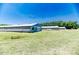 Exterior view of outbuildings on large property, set against a clear blue sky and green landscape at 2642 Holly Springs Church Rd, Broadway, NC 27505
