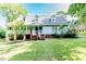 Charming two-story home with light green siding, dormer windows, and a well-manicured lawn at 2642 Holly Springs Church Rd, Broadway, NC 27505