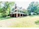 Two-story home with a brick foundation, green siding, and a white wooden porch railing at 2642 Holly Springs Church Rd, Broadway, NC 27505