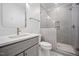 Modern bathroom features gray tiled shower, glass door, and vanity with a white countertop and gray cabinets at 2713 Trifle Lane Ln, Wake Forest, NC 27587