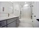 Well-lit bathroom with gray vanity, a white countertop, and a shower-tub with a tiled surround at 2713 Trifle Lane Ln, Wake Forest, NC 27587