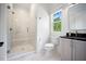Bright bathroom with a glass-enclosed shower, white marble tile, and a vanity with a black countertop at 2713 Trifle Lane Ln, Wake Forest, NC 27587