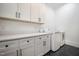 Bright laundry room boasts white cabinetry, sleek countertops, and modern washer and dryer at 2713 Trifle Lane Ln, Wake Forest, NC 27587