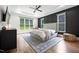 Spacious main bedroom with hardwood floors, a tray ceiling with fan, and a large window overlooking the backyard at 2713 Trifle Lane Ln, Wake Forest, NC 27587