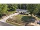 An aerial view shows a single-story home, long driveway, large grassy yard, and a peaceful, wooded surrounding at 282 Cooke Rd, Louisburg, NC 27549