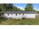 View of the backyard features a home with white siding, a deck, and green grass at 282 Cooke Rd, Louisburg, NC 27549