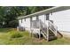 View of the backyard featuring a white house with a wooden deck and a well-maintained lawn at 282 Cooke Rd, Louisburg, NC 27549