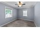 Cozy bedroom featuring two windows, ceiling fan, and modern laminate flooring at 282 Cooke Rd, Louisburg, NC 27549