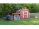 Red outbuilding with double doors and ample storage space at 282 Cooke Rd, Louisburg, NC 27549