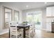 Inviting dining area with a dark wood table, seating for six, and access to a bright outdoor patio at 303 Rothbury Ct, Sanford, NC 27330