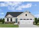Charming one-story home with stone accents, a blue door, and a well-manicured lawn under a bright blue sky at 303 Rothbury Ct, Sanford, NC 27330